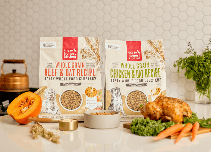 The Honest Kitchen's whole food clusters on a counter surrounded by real food ingredients. Our Impact.