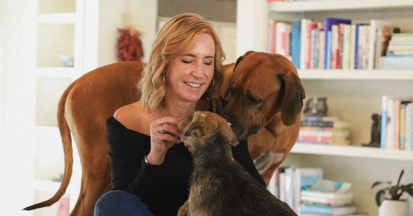 Lucy Postins with her two dogs in her living room.