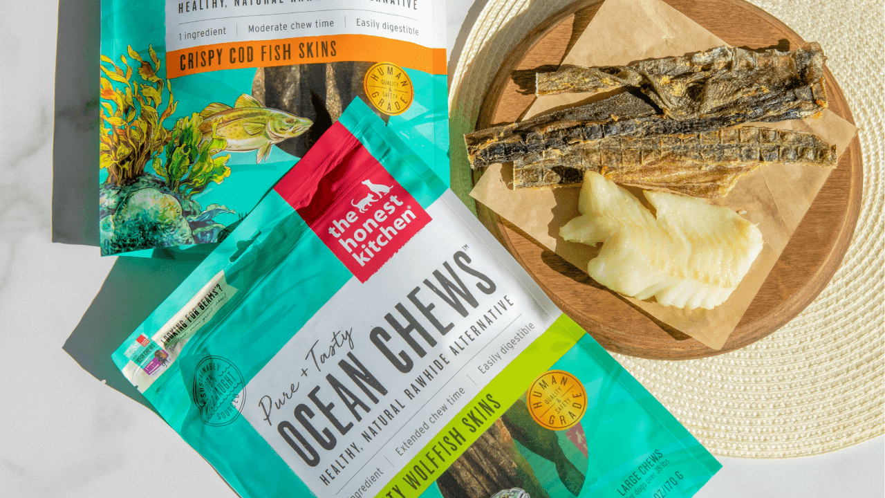 An image of the honest kitchen's ocean chews on a table with white fish and the product surrounding them. Shop single ingredient chews for dogs from the honest kitchen.