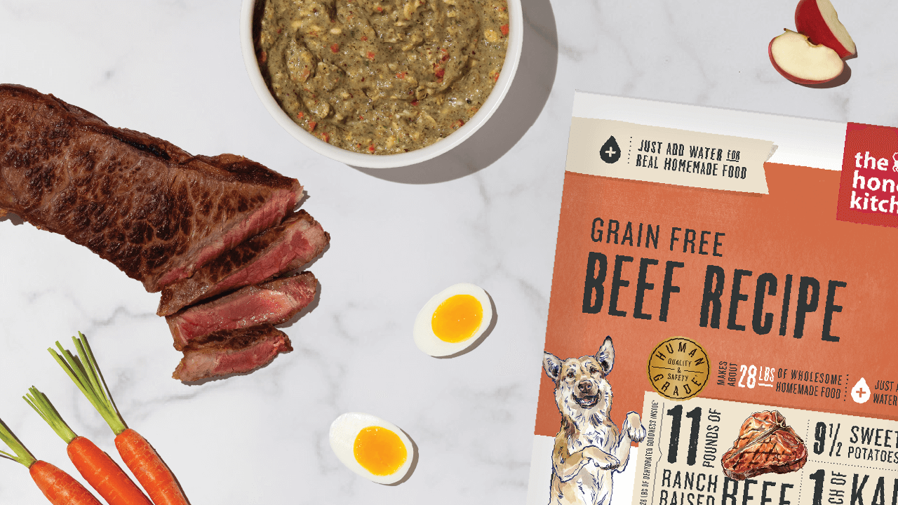 The Honest Kitchen Grain Free Beef Recipe dog food is displayed with beef slices, carrots, eggs, and apple slices. Shop high-protein dog food, treats, and toppers from The Honest Kitchen.